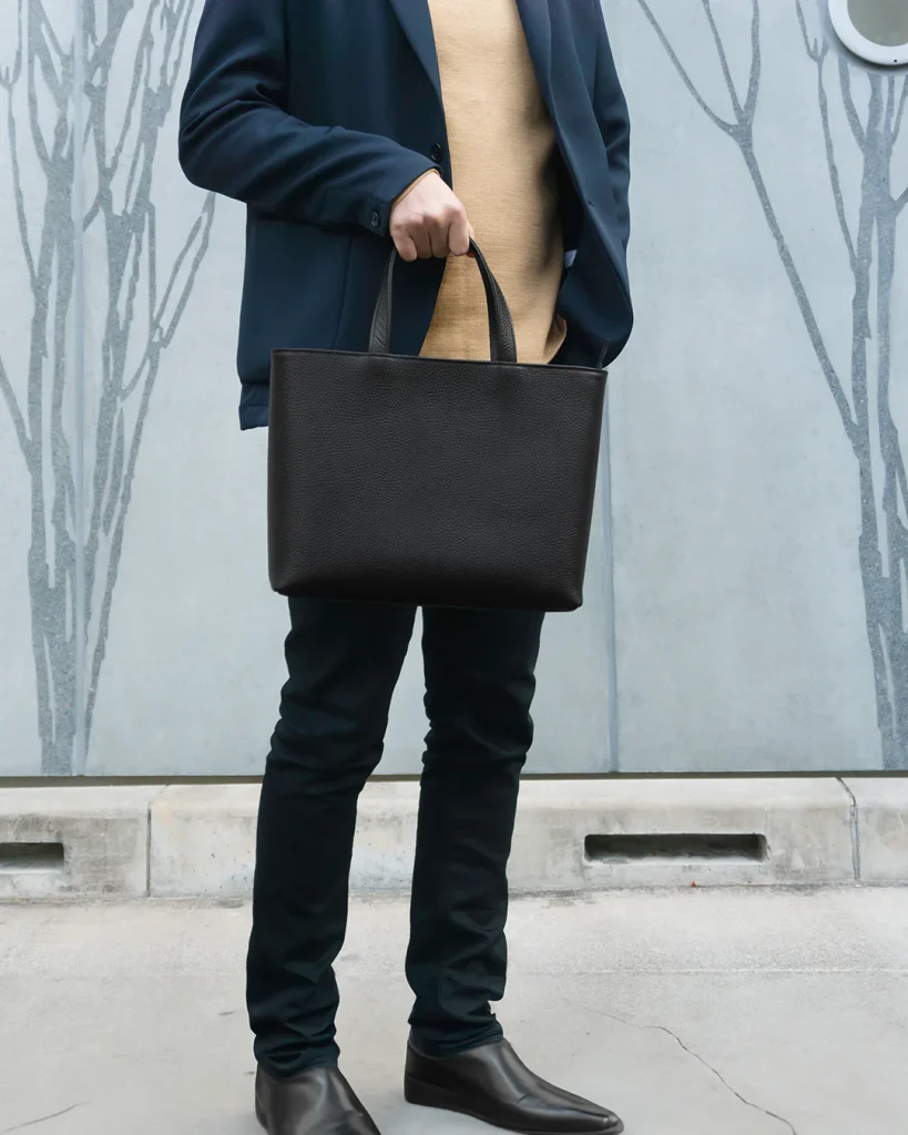 A person carrying a HushTug leather mini tote