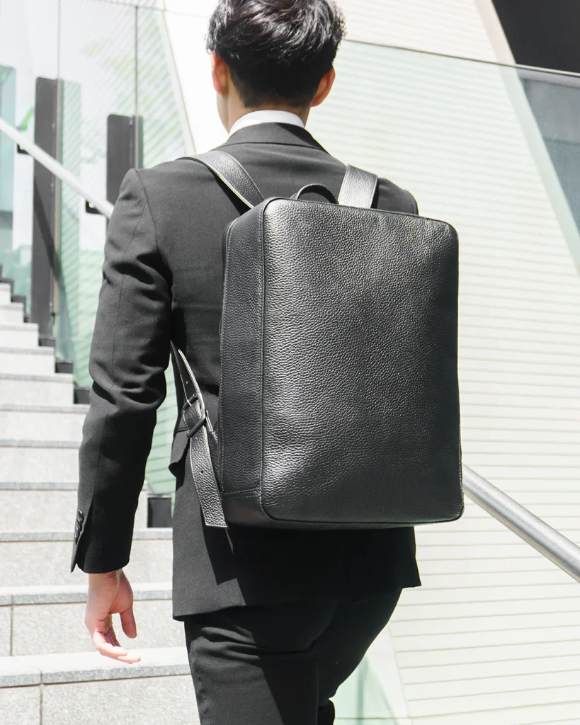 シンプルなリュックを背負う男性のイメージ