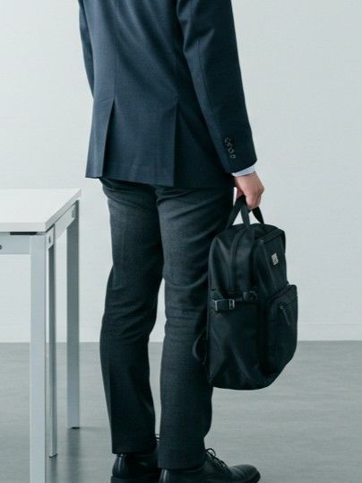 リュックを手で持つ男性のイメージ