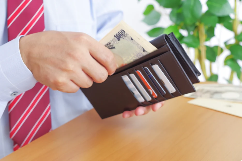 長財布からお金を取り出す様子
