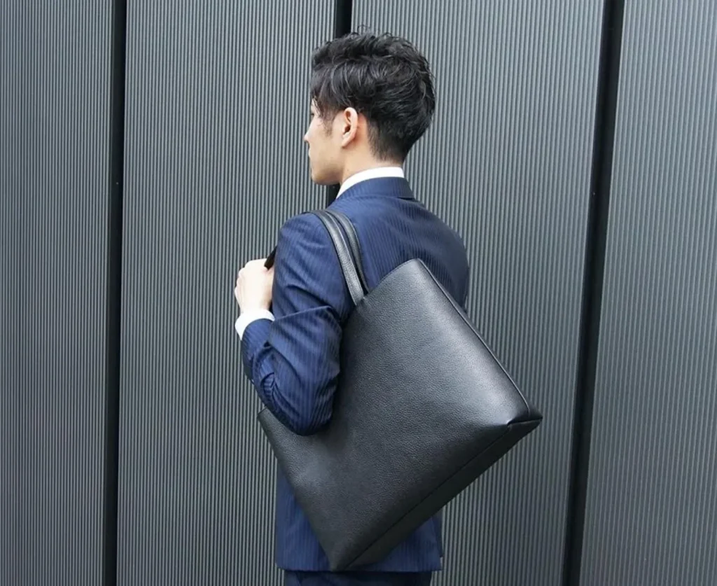 HushTugのレザートートを身につけた男性の画像